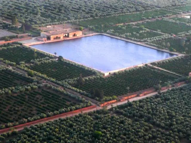 Un grand bassin au milieu des vergers, vu du ciel